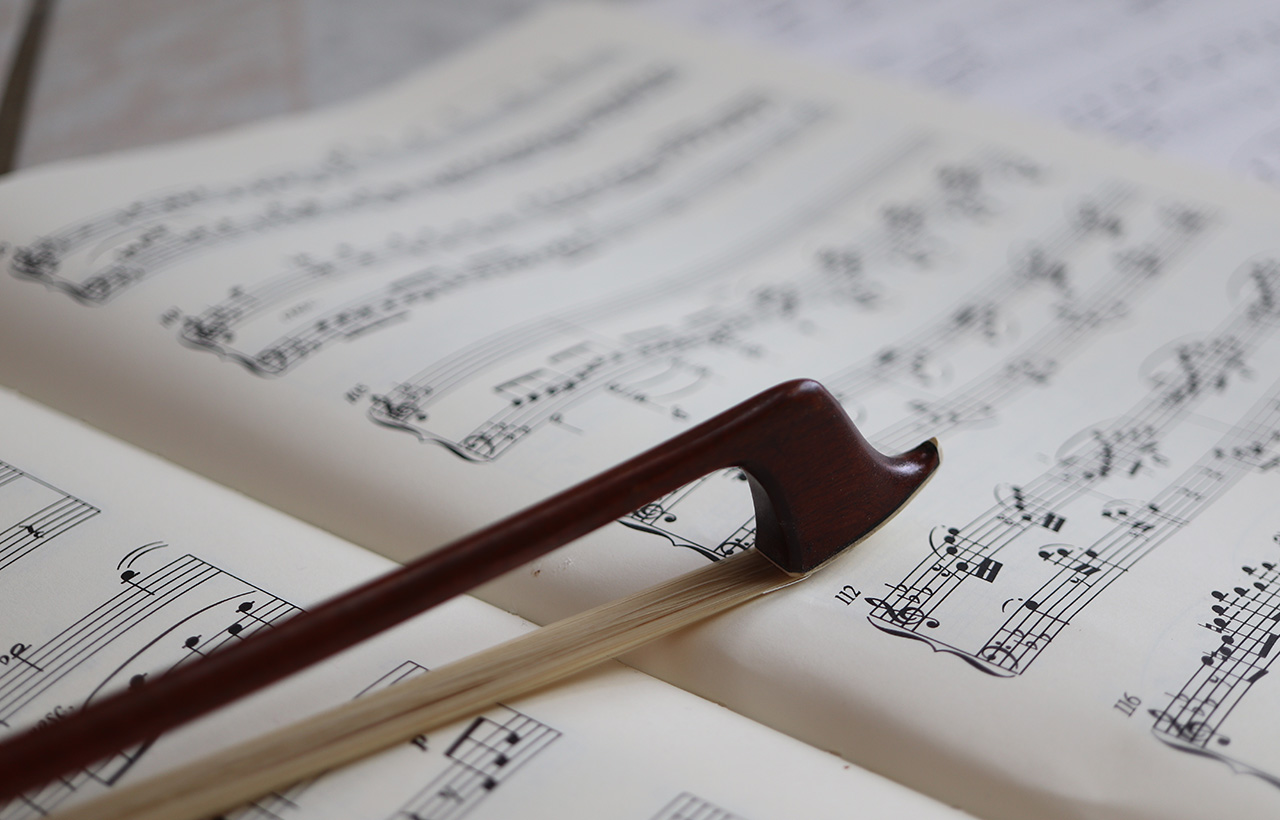 Violin bow against open sheet music