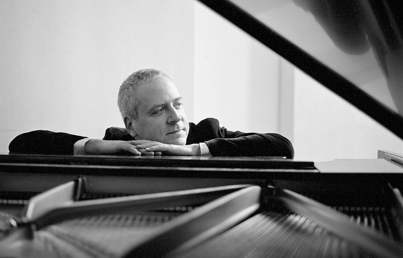 Jeremy Denk seated at piano with open lid